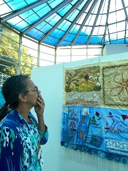 Arte Transformando mulher ao visitar uma exposição de bordados