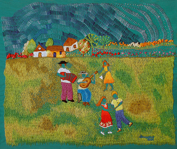 Bordado artesanal representando uma festa de Dia de Reis, com pessoas dançando e tocando sanfona e violão em um gramado verde, ao fundo casas rurais, árvores floridas e um céu azul em movimento.